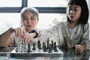 A nanny and a child playing chess together - Darren Yaw Cambodia